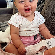 Sutton joined the competition — help win amazing prizes! baby, child, infant, smiling, happy, portrait, sitting, indoor, home, couch, blanket, clothing, pink, floral, blue_eyes, face, kitchen, bottle, cup, photography