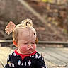 child, toddler, baby, portrait, pouting, serious_expression, rosy_cheeks, blonde_hair, hair_bow, topknot, outdoor, sunlight, patio, brick_wall, penguin_pattern, long_sleeves, fashion, standing, close_up, playful