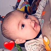 Nao participe au concours pour gagner de l'argent avec cette photo : baby, infant, child, face, eyes, smile, cheeks, toy, plush_toy, play_gym, blanket, onesie, cozy, heart_sticker, close_up, portrait, indoor, lying_down, adorable, clothing