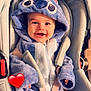baby, infant, child, smile, blue_hoodie, plush_costume, car_seat, stroller, seatbelt, happiness, portrait, cute, hand, hood, zipper, indoor, baby_face, red_heart_sticker, soft_texture, clothing