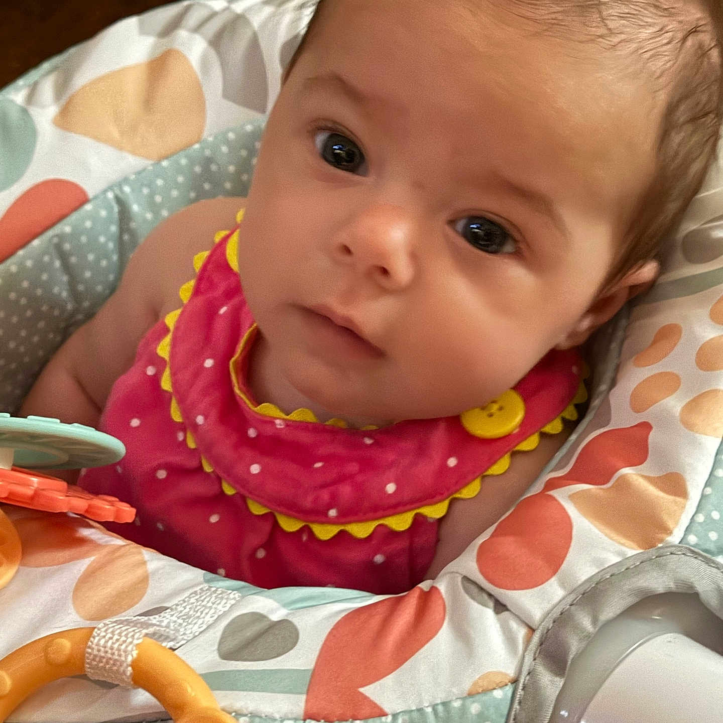 Jocelynn is registered to the contest to win money with this photo: adorable, baby, baby_seat, child, closeup, clothing, cute, expression, eyes, face, head, indoor, infant, person, pink_outfit, polka_dots, portrait, soft_lighting, toy, yellow_button