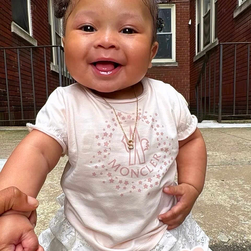 Sa'Hasyna joined the competition — help win amazing prizes! baby, child, smiling, holding_hand, outdoor, concrete, brick_building, tshirt, skirt, pigtails, necklace, happy, person, cute, portrait, daylight, young_child, fashion, hand, urban