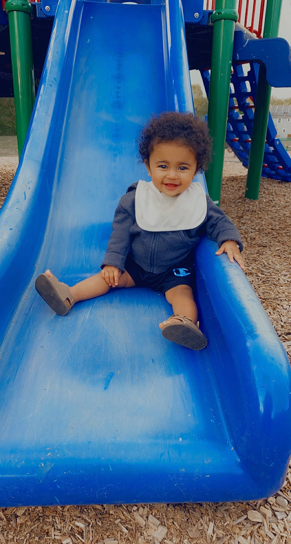 Leilanni is registered to the contest to win money with this photo: aqua, baby_toddler_clothing, blue, child, chute, city, electric_blue, fun, grass, green, joy, leisure, outdoor_play_equipment, person, photograph, play, playground, playground_slide, recreation, smile