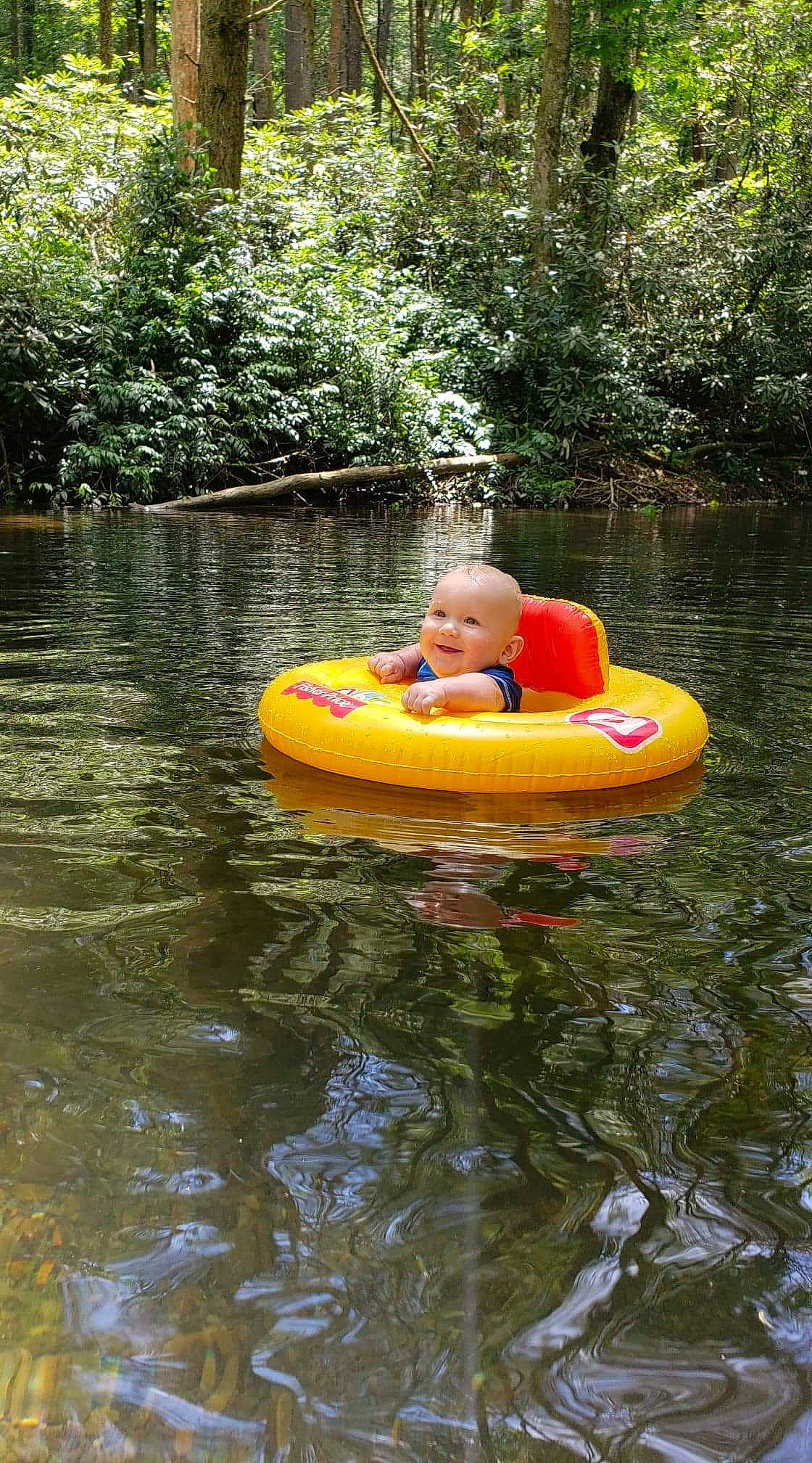 Tracy is registered to the contest to win money with this photo: bank, bayou, boat, boating, fun, joy, lake, leisure, person, pond, recreation, river, tree, tubing, vacation, vehicle, water, water_transportation, watercourse, watercraft