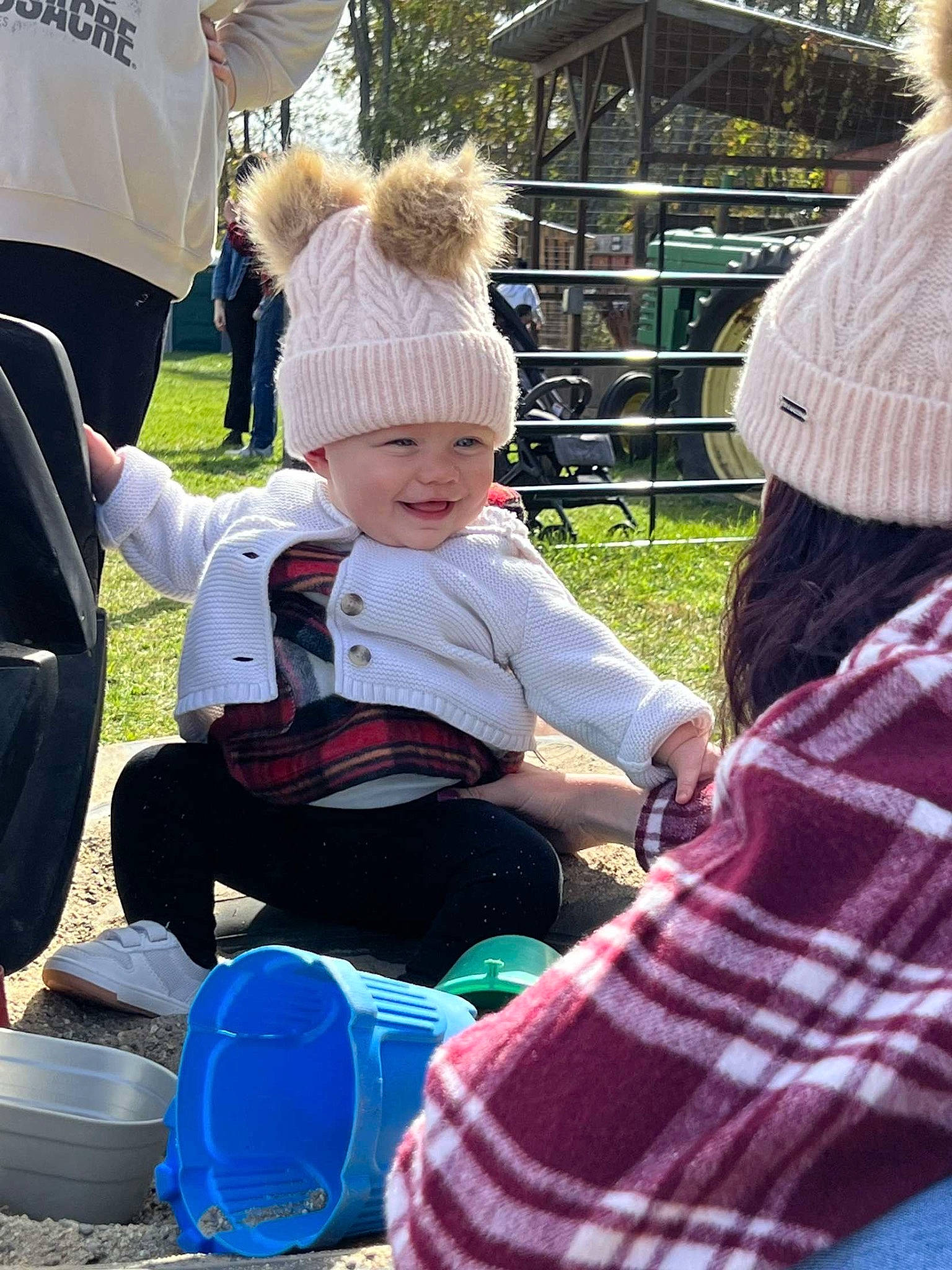 Annalise joined the competition — help win amazing prizes! baby, cap, child, community, event, fence, fun, grass, green, hat, headwear, joy, lap, leisure, pattern, person, plaid, plant, recreation, sitting