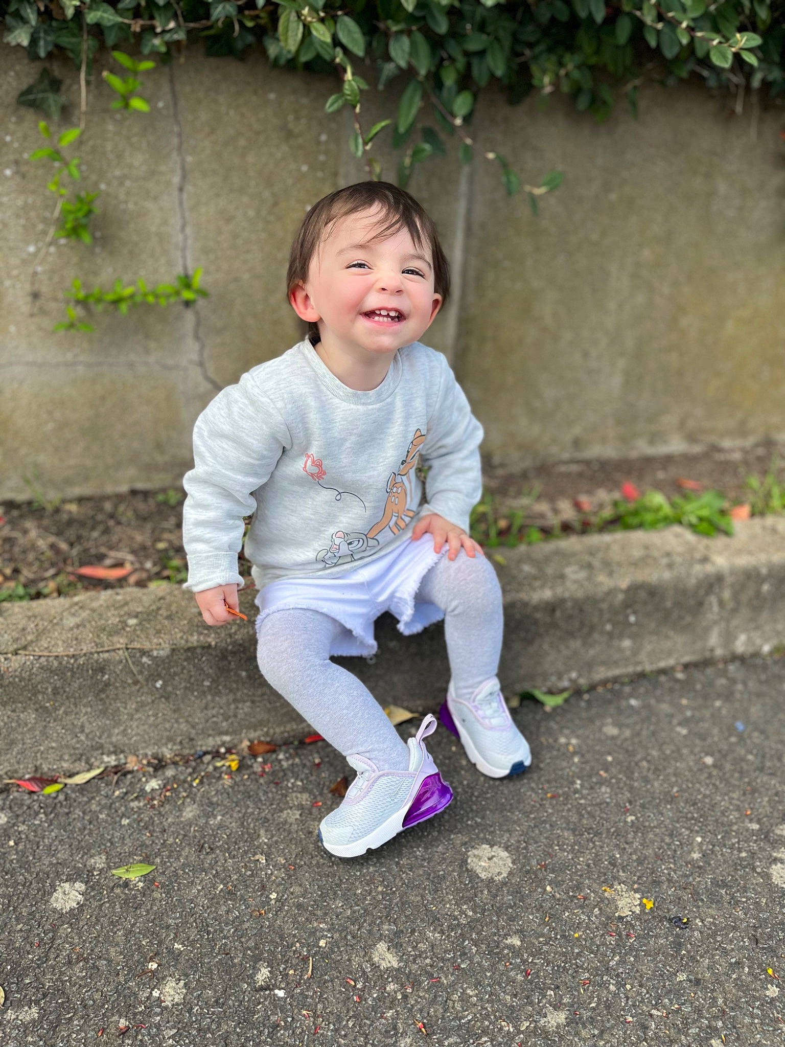Kélyana participe au concours pour gagner de l'argent avec cette photo : asphalt, baby_toddler_clothing, botany, eye, face, grass, hair, happy, head, human_body, joy, leaf, leisure, people_in_nature, person, plant, road_surface, sitting, sleeve, smile