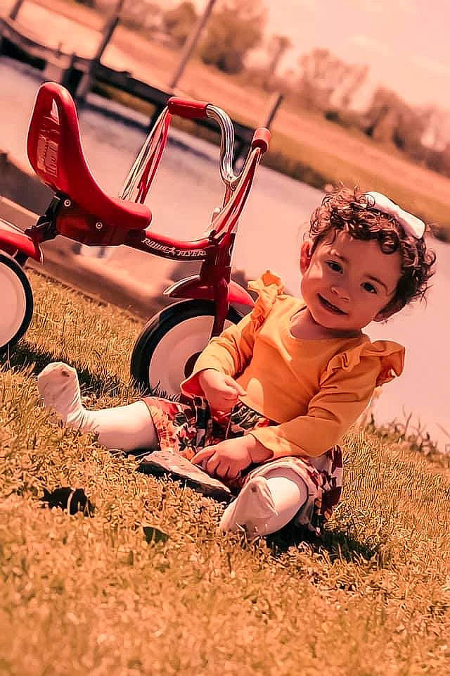 Arya is registered to the contest to win money with this photo: baby, bicycle_handlebar, carmine, child, fun, grass, happy, human_leg, joy, landscape, leisure, people_in_nature, person, personal_protective_equipment, play, recreation, sandal, sitting, soil, swing