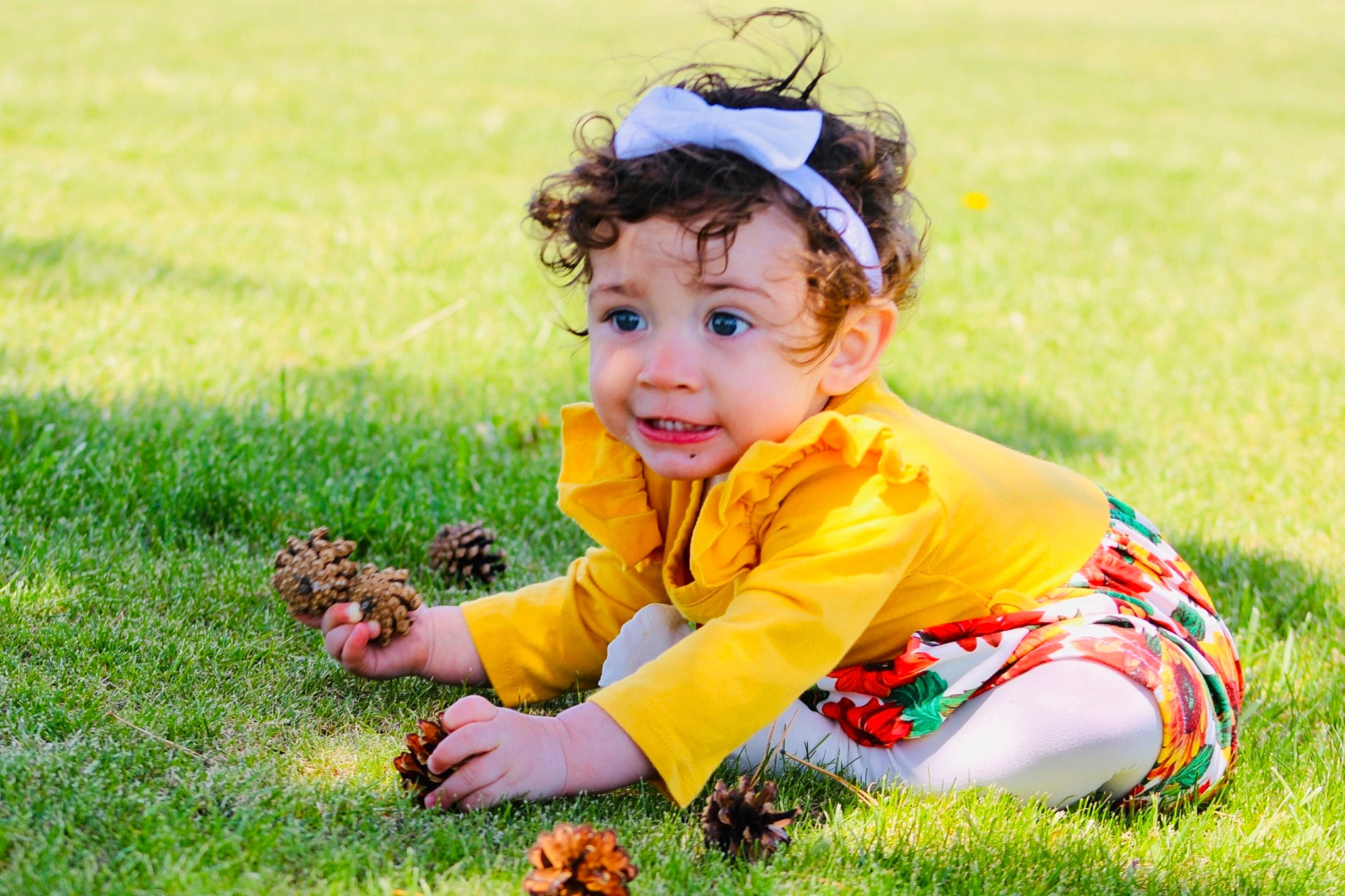 Arya is registered to the contest to win money with this photo: baby, baby_toddler_clothing, dress, eye, fun, grass, grass_family, grassland, happy, head, lawn, leaf, leisure, meadow, people_in_nature, person, plant, recreation, sitting, smile