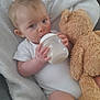 Logan joined the competition — help win amazing prizes! baby, bottle, milk, teddy_bear, towel, infant, onesie, cuddly_toy, blue_eyes, hand, face, soft_texture, cute, lying_down, child, feeding, comfort, indoor, closeup, young