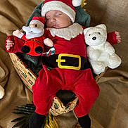 Aaron a rejoint le concours — aidez-le/la à gagner de superbes lots ! baby, sleeping, santa_hat, red_clothing, plush_toy, teddy_bear, basket, holiday, christmas, festive, blanket, soft_toy, cute, infant, cozy, decorations, wrapped, fabric, sleep, child