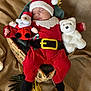 baby, sleeping, santa_hat, red_clothing, plush_toy, teddy_bear, basket, holiday, christmas, festive, blanket, soft_toy, cute, infant, cozy, decorations, wrapped, fabric, sleep, child