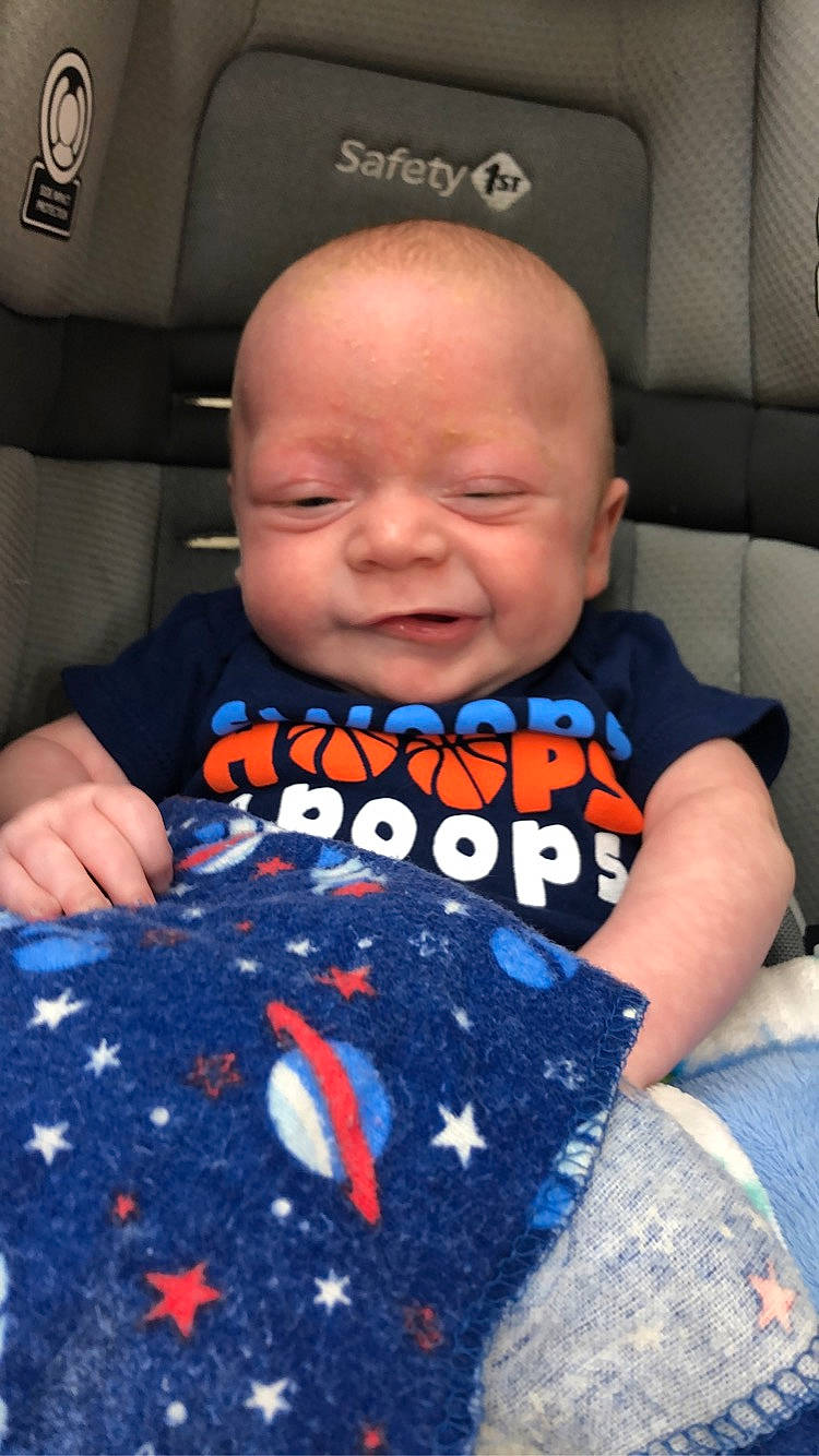 Kyran is registered to the contest to win money with this photo: baby, baby_toddler_clothing, car_seat, child, comfort, cool, electric_blue, finger, happy, head, linens, pattern, person, product, sitting, skin, sleeve, smile, t_shirt, textile