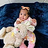 baby, blue_background, bow, child, clothing, cozy, cute, feet, happy, headband, indoors, infant, orange, pink, plush_toy, portrait, sitting, smile, soft_toy, teddy_bear