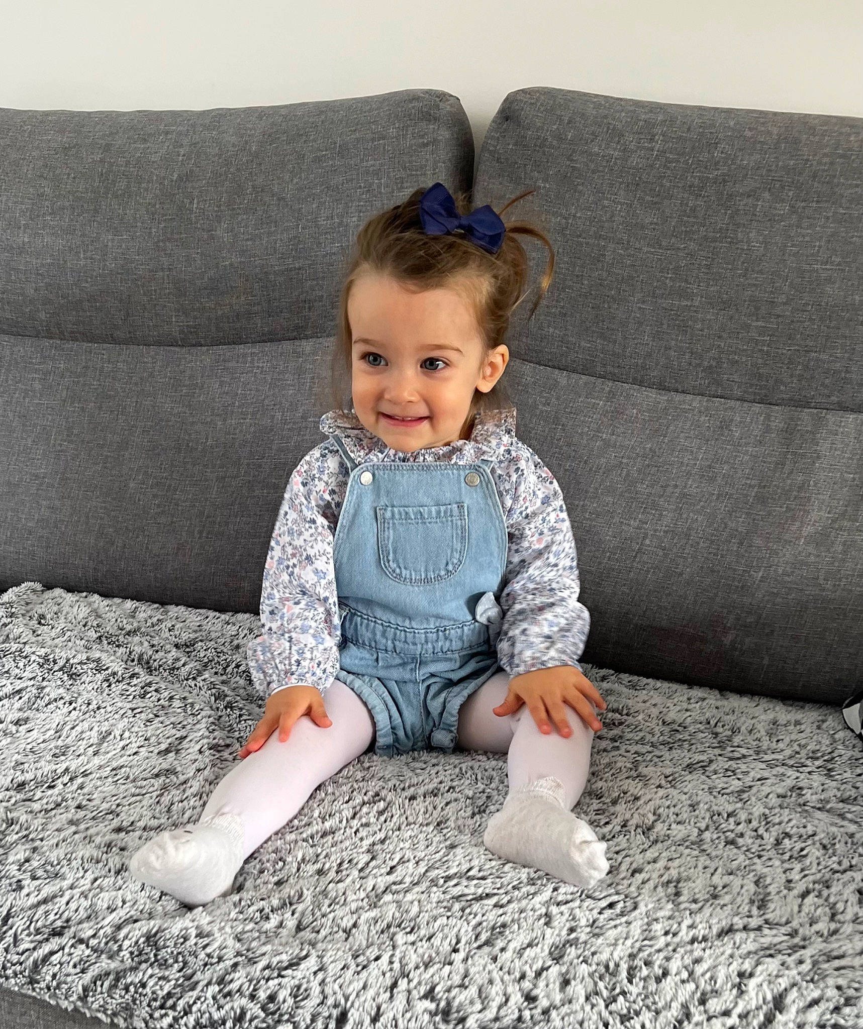 Sofia a rejoint le concours — aidez-le/la à gagner de superbes lots ! baby, baby_toddler_clothing, child, comfort, couch, electric_blue, eye, face, grey, happy, head, joy, linens, pattern, person, rectangle, sitting, sleeve, smile, t_shirt
