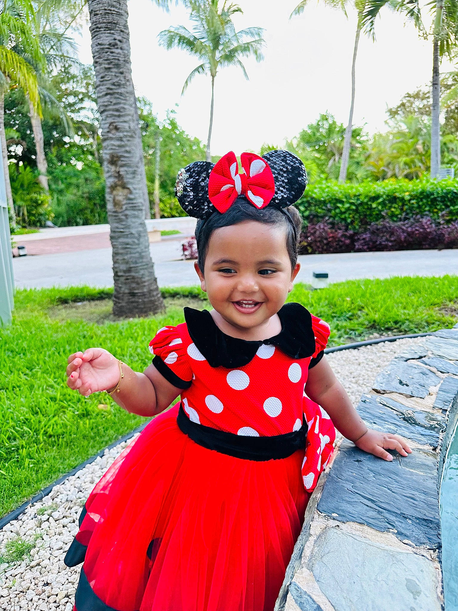 Madina is registered to the contest to win money with this photo: baby_toddler_clothing, botany, child, day_dress, event, fun, grass, happy, headgear, joy, leisure, magenta, palm_tree, pattern, person, pink, plant, sky, smile, summer