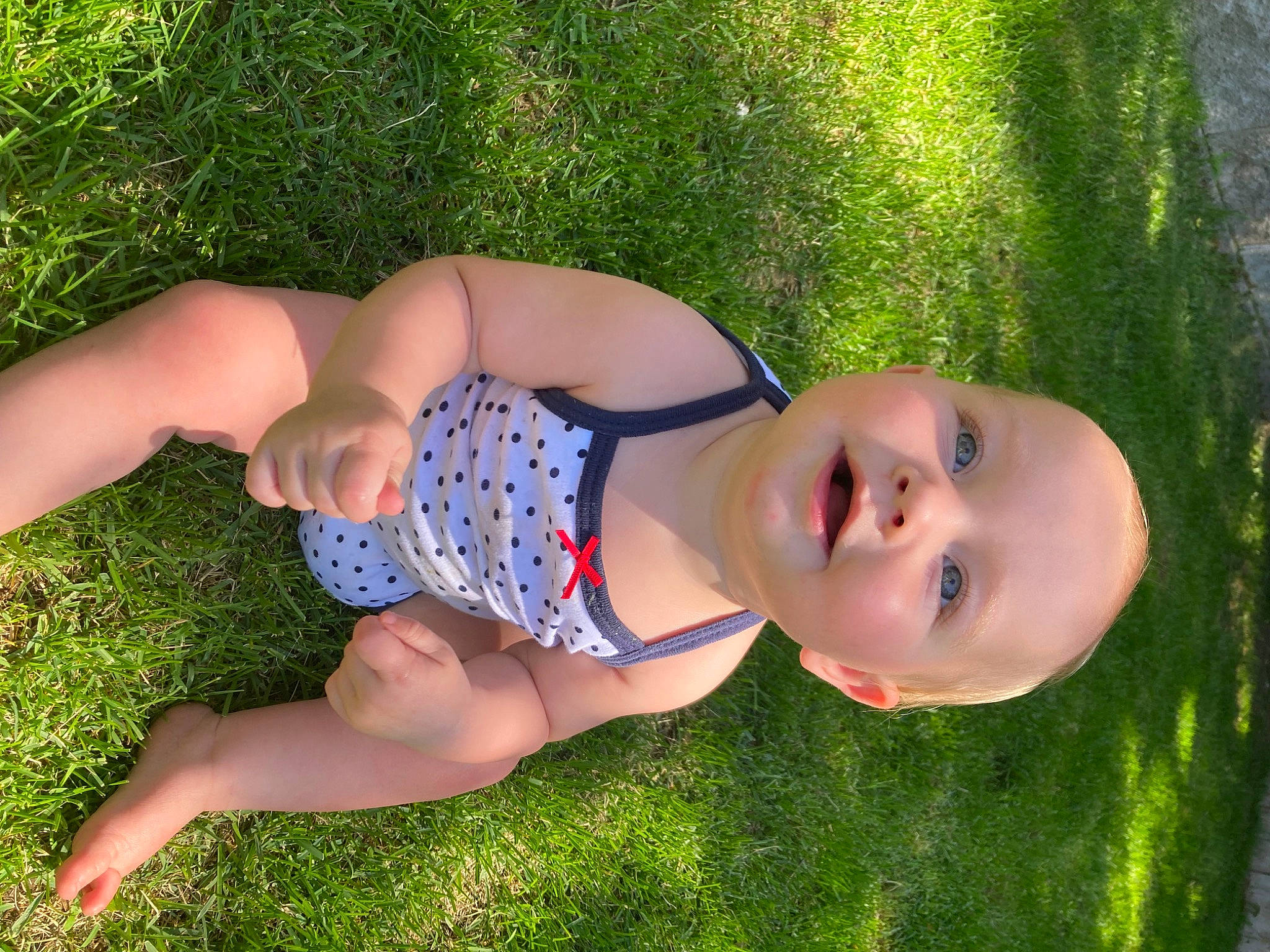 Emilie joined the competition — help win amazing prizes! baby_toddler_clothing, chest, finger, fun, grass, hand, happy, human_body, human_leg, knee, leaf, leg, leisure, meadow, people_in_nature, person, plant, sunlight, thigh, toddler