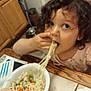 Deanna is registered to the contest to win money with this photo: child, toddler, noodles, food, bowl, table, kitchen, curly_hair, eating, vegetables, orange_bowl, plate, person, indoor, meal, messy, cute, young_child, dining, casual