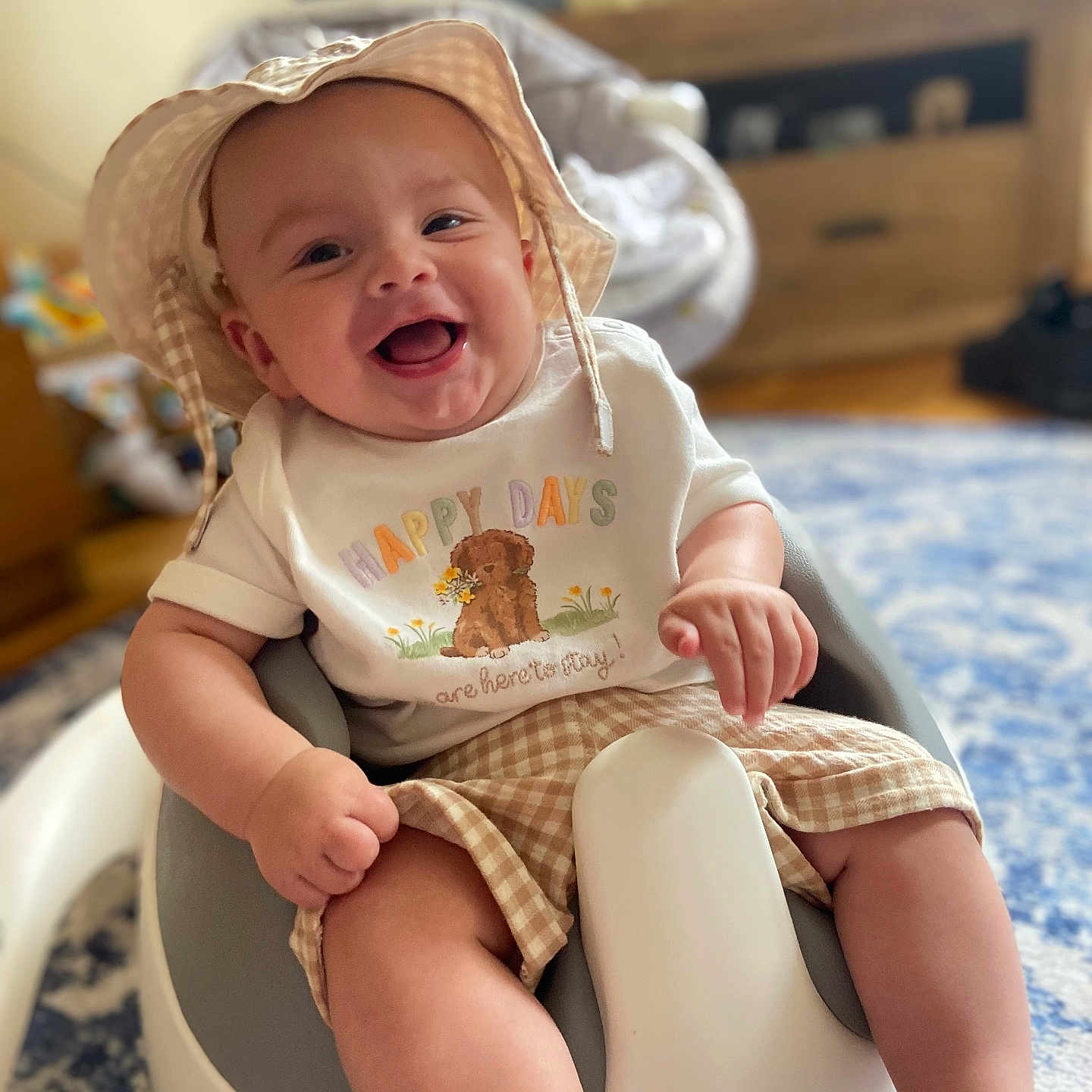 Ayfee is registered to the contest to win money with this photo: apparel, baby, baby_seat, carpet, cheerful, child, clothing, cute, furniture, happy, hat, home, indoor, infant, person, portrait, seat, shorts, smiling, toddler