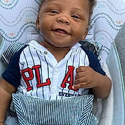 Kajani joined the competition — help win amazing prizes! baby, smiling, infant, clothing, striped_shirt, overalls, seat, pattern, hand_gesture, happy, face, cute, child, portrait, indoor, fabric, button, blue, white, red