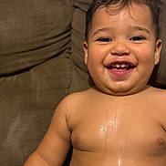 Yadiel is registered to the contest to win money with this photo: toddler, child, baby, smiling, laughing, portrait, face, teeth, eyes, hair, bare_chested, sitting, couch, cushion, indoor, home, closeup, happy, playful, photography