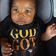 Jermany joined the competition — help win amazing prizes! baby, black, car_seat, child, close_up, clothing, cushion, cute, expression, eyes, face, gold_text, hands, indoor, infant, orange_text, person, portrait, shirt, young