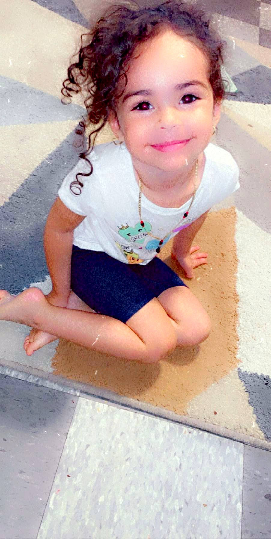 Bryelle is registered to the contest to win money with this photo: baby_toddler_clothing, barefoot, child, dress, fun, grass, happy, head, human_leg, joy, leisure, person, pink, recreation, sand, sitting, skin, sleeve, smile, snapshot