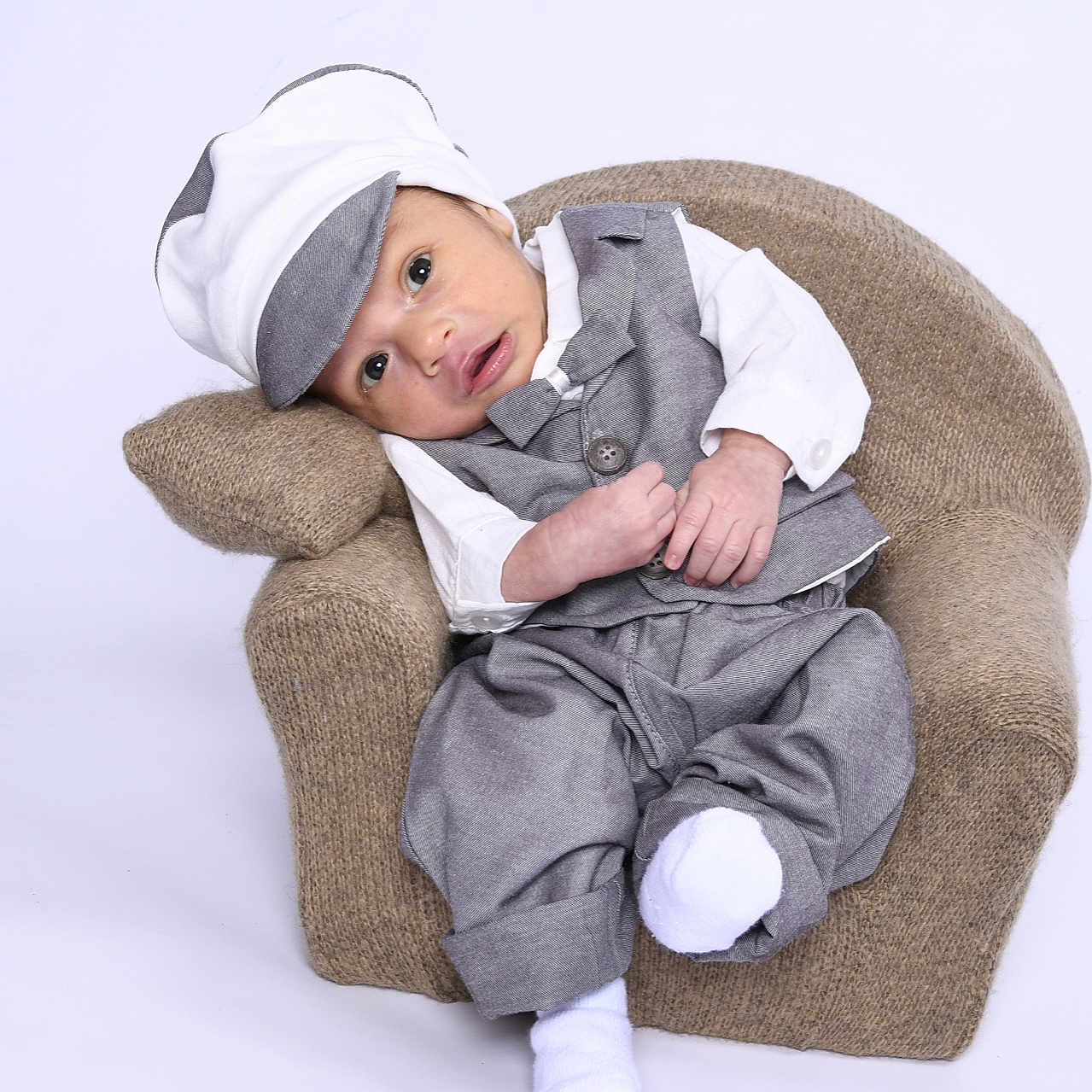 Cairo is registered to the contest to win money with this photo: armchair, baby, baseballcap, beanie, blanket, bodypart, bonnet, cap, chair, clothing, couch, cushion, doll, dress, face, finger, fleece, furniture, hand, happy