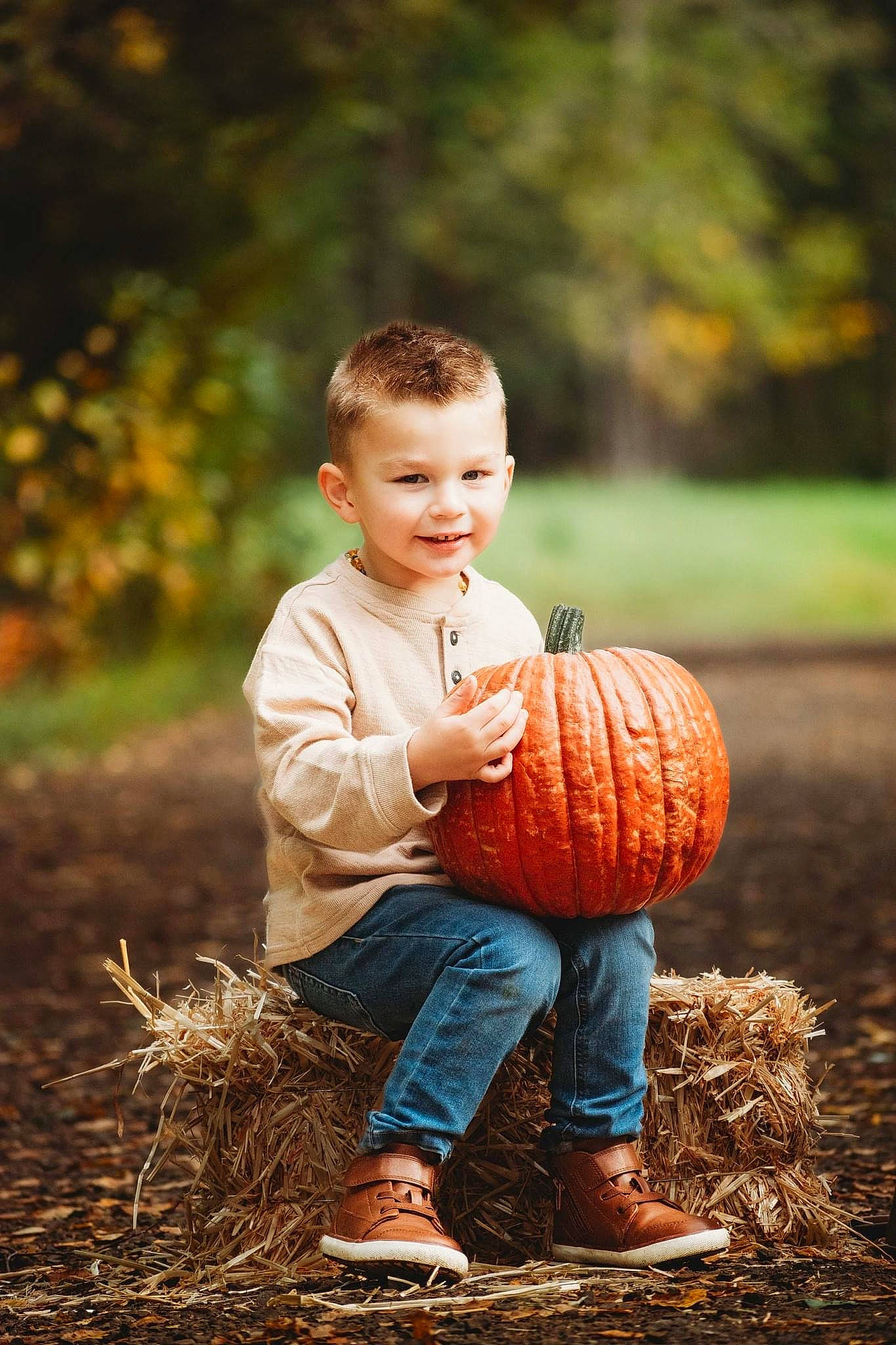 Lucas is registered to the contest to win money with this photo: baby_toddler_clothing, child, eye, flash_photography, gesture, grass, happy, head, jeans, joy, people, people_in_nature, person, plant, pumpkin, sitting, smile, standing, sunlight, toddler