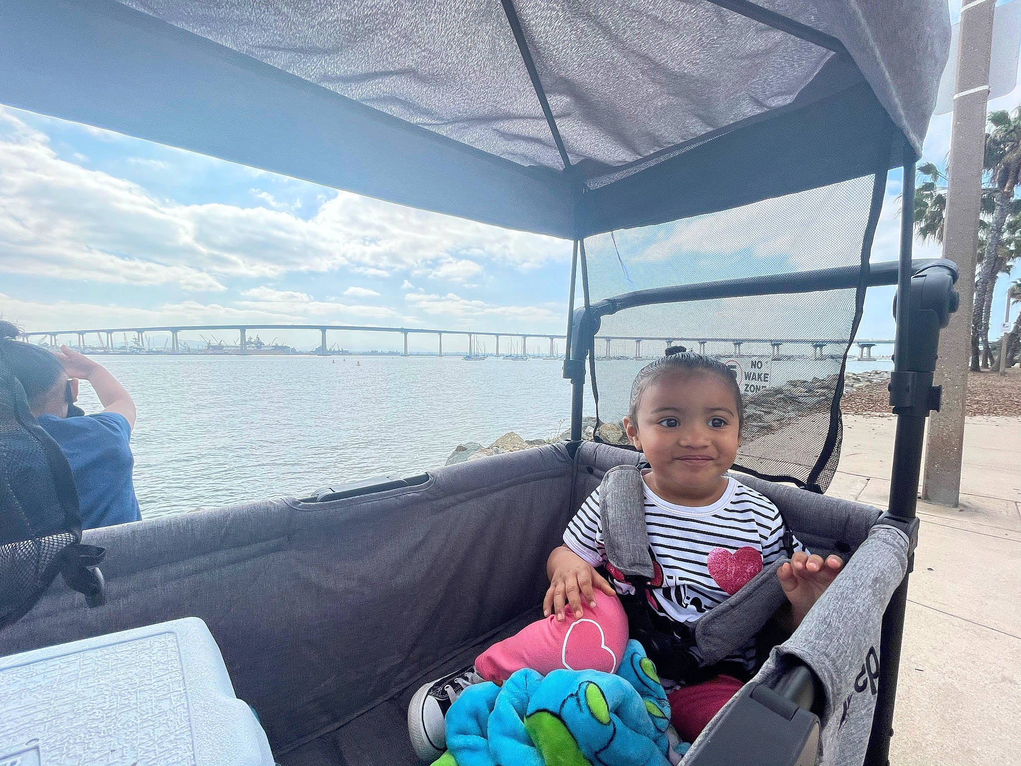 Haley is registered to the contest to win money with this photo: boats_and_boating_equipment_and_supplies, cloud, comfort, fun, joy, lake, leisure, morning, naval_architecture, person, recreation, shade, sitting, sky, smile, toddler, tourism, travel, tree, vacation