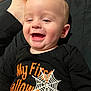 baby, child, smiling, happy, black_clothing, halloween, spiderweb, orange_text, infant, portrait, lying_down, casual, cute, human, person, closeup, head, face, skin, foot