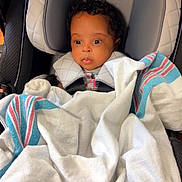 Novah joined the competition — help win amazing prizes! baby, car_seat, blanket, graco, child, infant, face, curly_hair, seatbelt, cozy, indoors, portrait, child_seat, soft_lighting, cute, wrapped, young_child, car_interior, sitting, secure