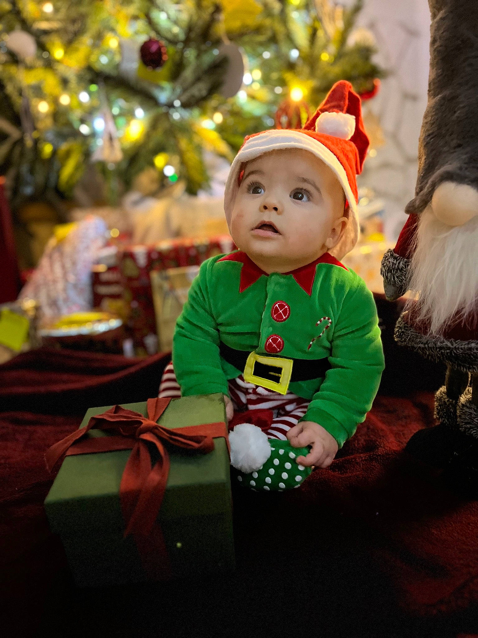 Leonardo participe au concours pour gagner de l'argent avec cette photo : baby, child, christmas, christmas_decoration, christmas_eve, christmas_ornament, christmas_tree, event, face, fun, happy, head, headwear, holiday, holiday_ornament, ornament, person, plant, toddler, tradition