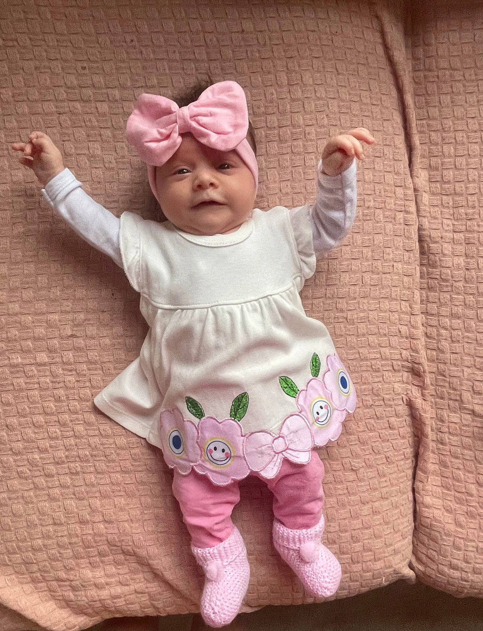 Ella participe au concours pour gagner de l'argent avec cette photo : arm, baby, baby_toddler_clothing, cap, cheek, dress, face, gesture, hand, happy, head, headwear, human_body, magenta, outerwear, pattern, person, pink, sleeve, textile