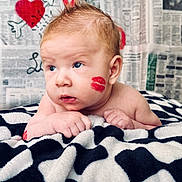 Riley joined the competition — help win amazing prizes! baby, infant, face, red_lipstick, kiss_mark, blanket, black_and_white, pattern, newspaper_background, heart_drawing, moawk_hairstyle, cute, child, skin, portrait, lying_down, expression, young, indoor, decor