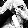 black_and_white, hand, dog_paw, towel, human, animal, texture, close_up, companion, pet, fur, skin, clothing, bond, resting, comfort, touch, relationship, friendship, indoor