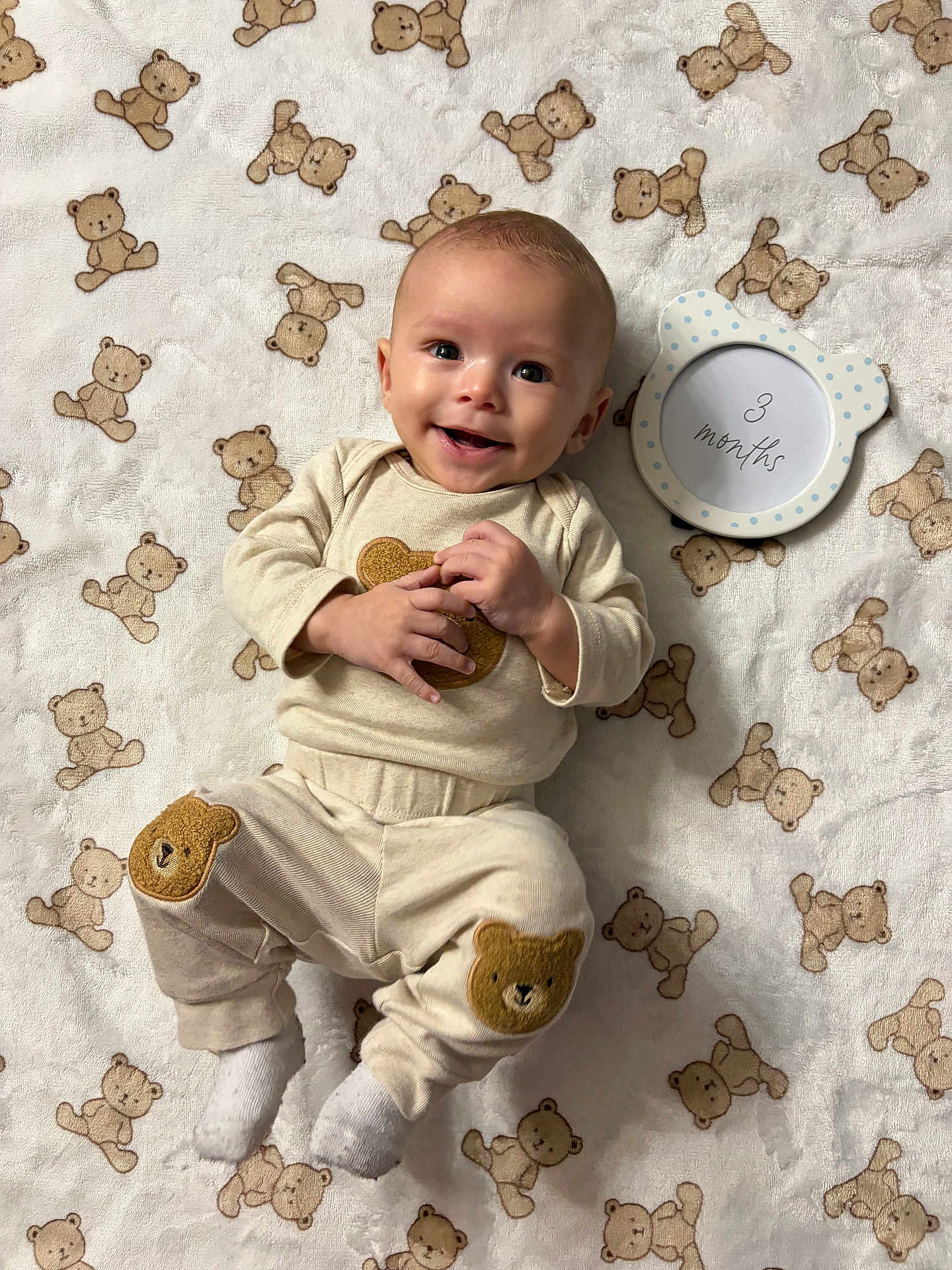 Elohim is registered to the contest to win money with this photo: age_marker, baby, bear_patch, blanket, child, clothing, cozy, cute, frame, happy, indoors, infant, lying_down, playful, portrait, smiling, soft_texture, teddy_bear_pattern, white_socks, young_child