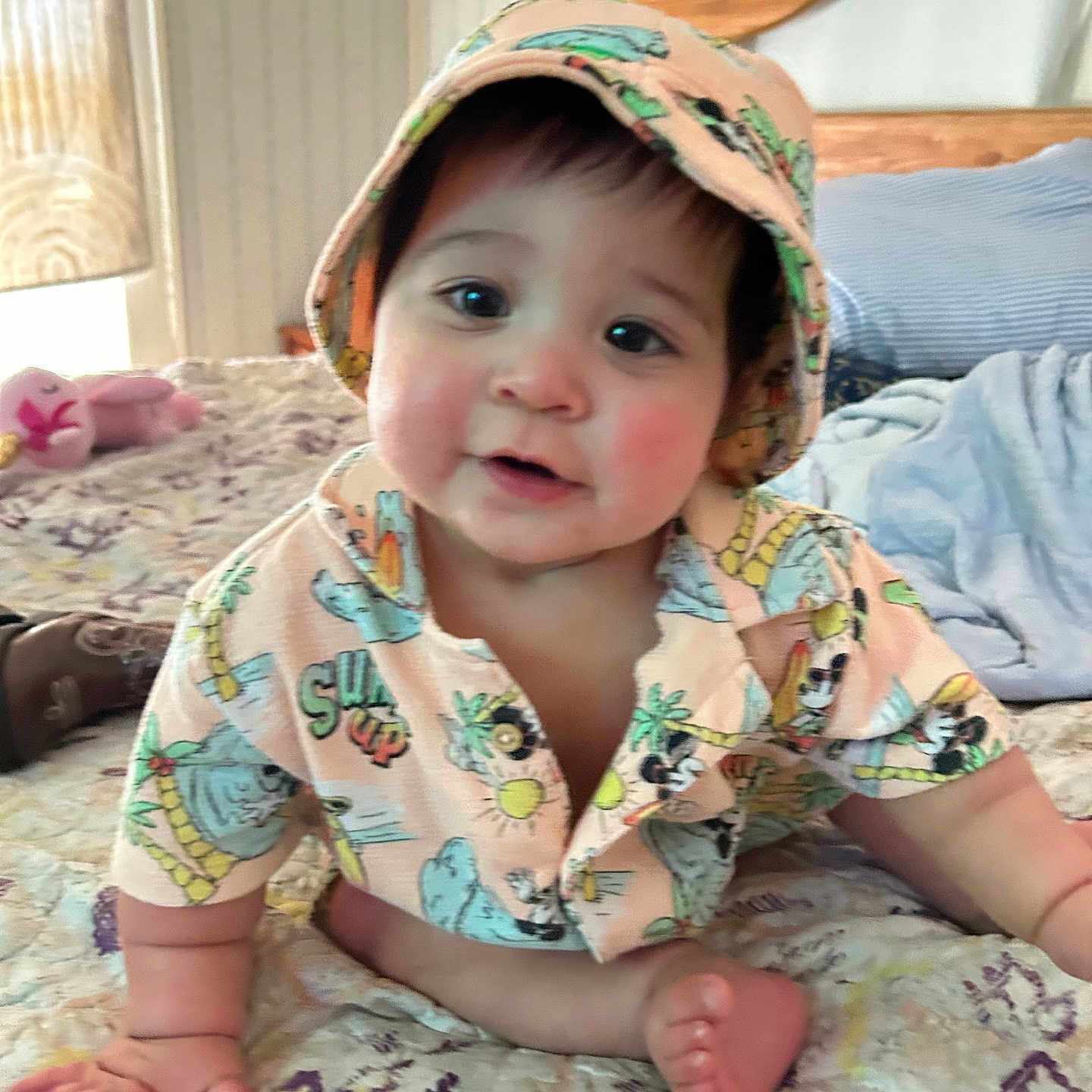 Bobbie is registered to the contest to win money with this photo: baby, bed, bedspread, blanket, child, crawling, cute, face, feet, hands, hat, indoor, infant, patterned, person, pillow, room, shirt, smiling, wooden_headboard