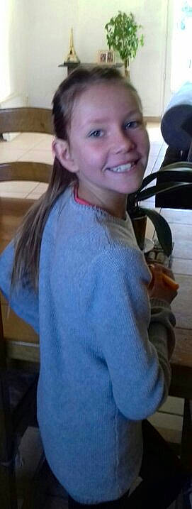 Emma participe au concours pour gagner de l'argent avec cette photo : arm, brown_hair, cheek, child, ear, face, facial_expression, hair, hairstyle, jaw, joy, long_hair, neck, outerwear, person, shoulder, sleeve, smile, t_shirt, toddler