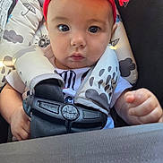 Ariella is registered to the contest to win money with this photo: baby, child, infant, headband, red_flower, car_seat, harness, seatbelt, closeup, face, eyes, hands, clothing, patterned, sitting, portrait, cute, indoors, person, young
