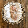 baby, basket, blanket, wooden_floor, headband, infant, sleeping, onesie, indoors, cute, peaceful, cozy, soft, resting, child, newborn, portrait, flooring, relaxing, comfortable