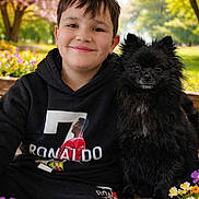 Veilko participe au concours pour gagner de l'argent avec cette photo : boy, dog, smile, hoodie, black_dog, bench, flowers, garden, spring, outdoor, greenery, portrait, child, pet, nature, happy, casual_clothing, tree, daylight, park