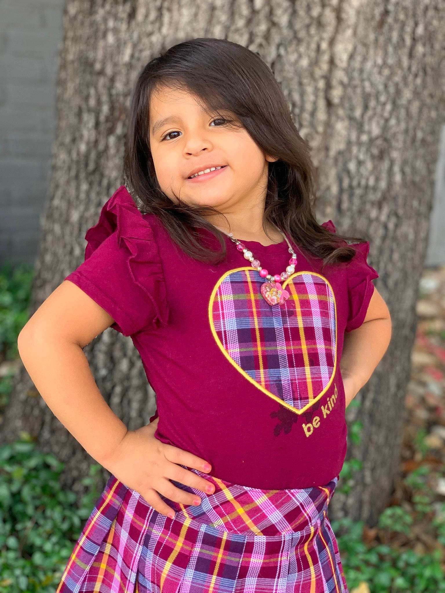 Jayda is registered to the contest to win money with this photo: flash_photography, grass, happy, joy, leaf, neck, outerwear, people_in_nature, person, pink, plaid, plant, red, school_uniform, shoulder, sleeve, smile, t_shirt, tartan, textile