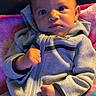 baby, child, infant, hoodie, gray_clothing, blanket, indoor, portrait, cute, hands, face, eyes, sitting, young_child, cozy, warm, expression, person, soft_texture, casual_wear