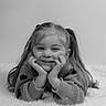 Azëlia participe au concours pour gagner de l'argent avec cette photo : child, girl, smiling, pigtails, sweater, portrait, black_and_white, happy, face, hands, lying_down, blanket, cozy, cute, hair, young, innocent, resting, expression, studio