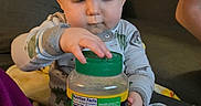 Jayce is registered to the contest to win money with this photo: baby, cat, child, clothing, couch, cozy, curious, face, furniture, hand, home, indoor, jar, living_room, pajamas, person, pet, seasoning, sitting, toddler