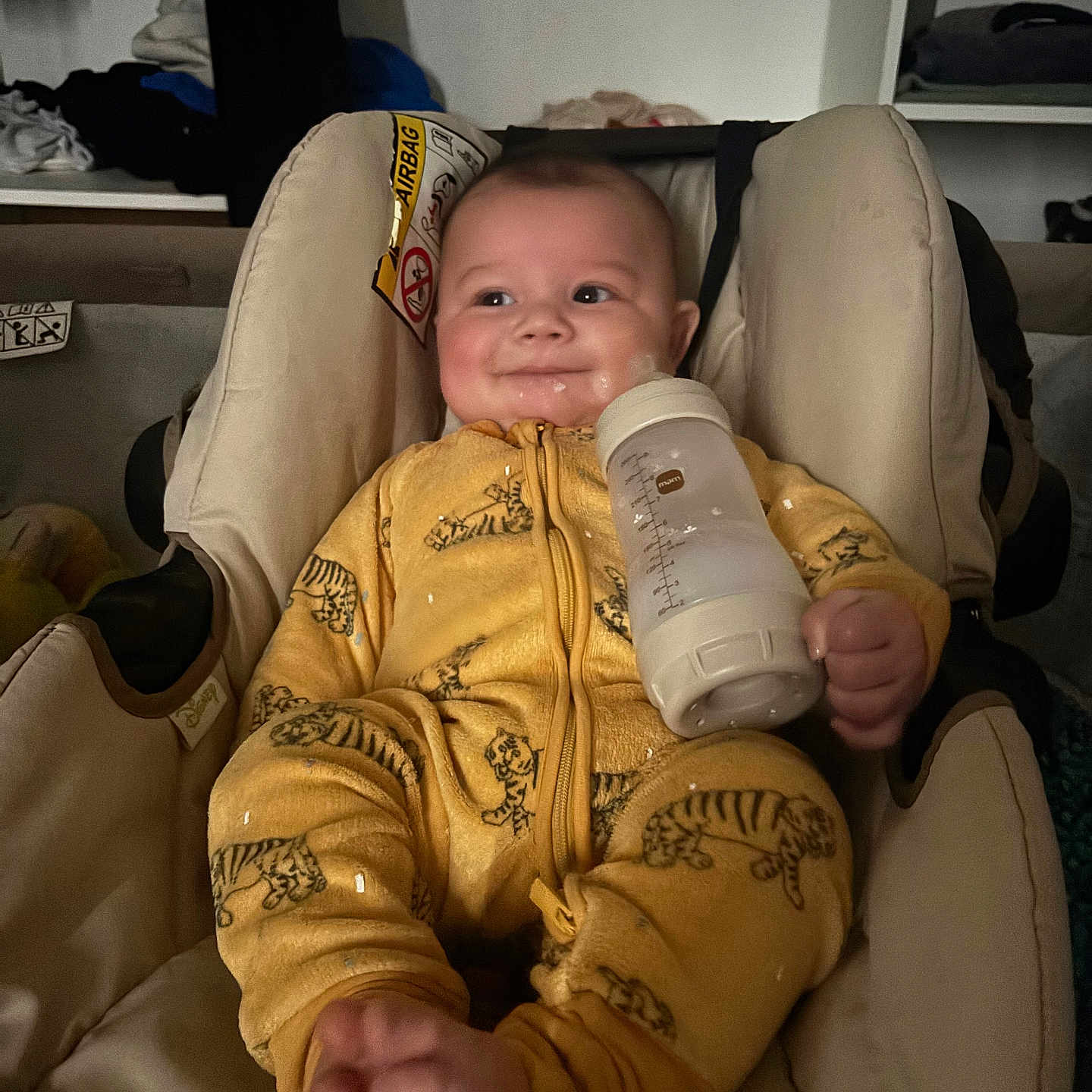 Khelid a rejoint le concours — aidez-le/la à gagner de superbes lots ! baby, bottle, car_seat, cheeks, clothing, cozy, cute, face, feet, hands, indoor, infant, milk, portrait, seat_padding, smile, soft_lighting, tiger_print, warning_label, yellow_onesie