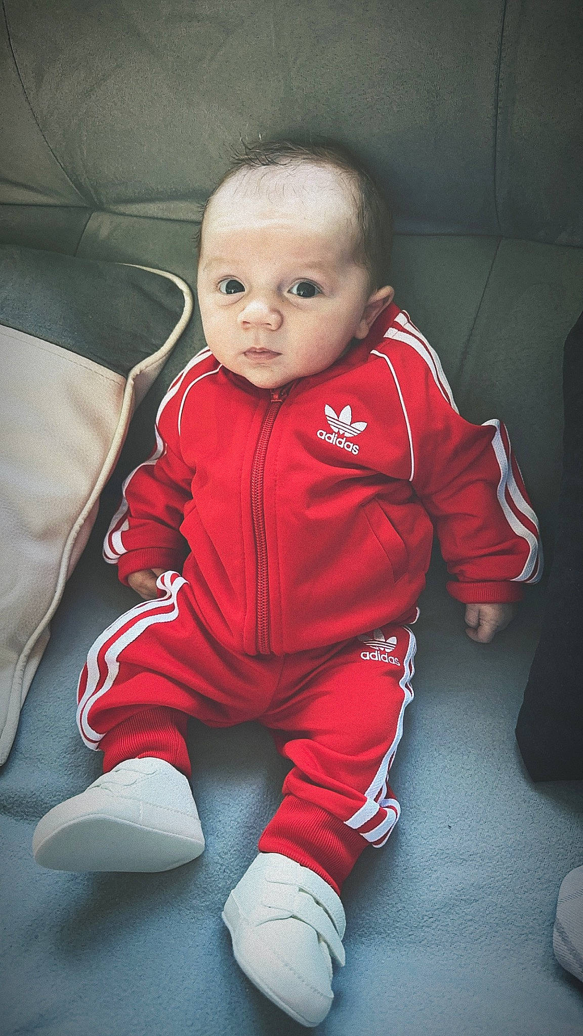Noah participe au concours pour gagner de l'argent avec cette photo : baby, baby_toddler_clothing, carmine, cheek, child, comfort, flooring, fun, fur, human_leg, iris, knee, linens, lip, nose, person, sitting, sleeve, smile, thumb