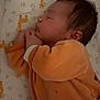 Noé a rejoint le concours — aidez-le/la à gagner de superbes lots ! baby, sleeping, infant, orange_clothing, giraffe_pattern, bed, crib, pajamas, peaceful, cute, newborn, child, soft_lighting, indoors, rest, profile, face, hands, blanket, cozy
