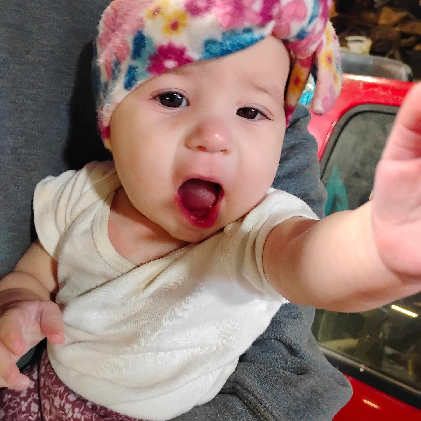 Enola joined the competition — help win amazing prizes! baby, baseballcap, beanie, bodypart, bonnet, cap, clothing, couch, eating, face, finger, food, hand, hat, head, mouth, person, photography, portrait, tongue