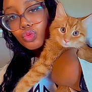 Cheesy joined the competition — help win amazing prizes! person, glasses, cat, orange_cat, pet, selfie, pout, headband, braids, indoor, wall, white_shirt, arm, fur, whiskers, close_up, looking_at_camera, eyes, face, portrait
